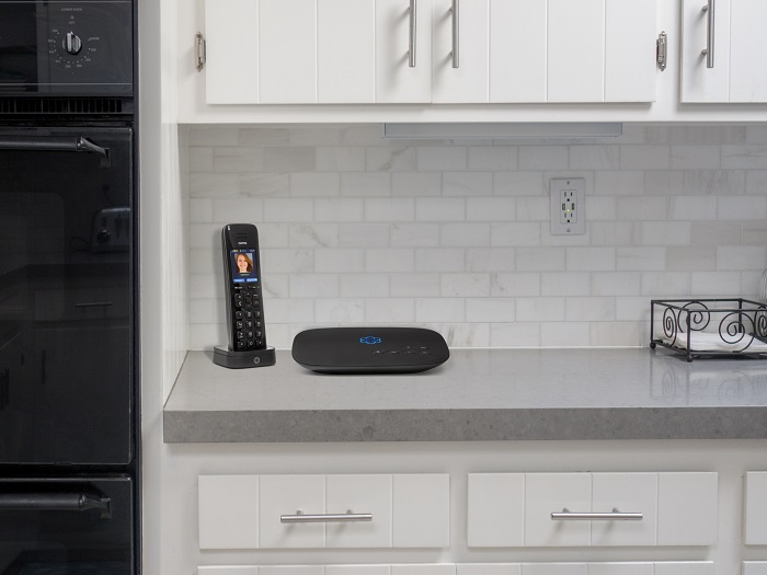 Ooma phone and base station sit on a kitchen countertop